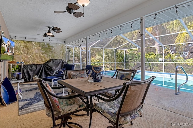 view of patio featuring glass enclosure and ceiling fan