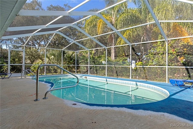 view of swimming pool featuring glass enclosure and a patio area