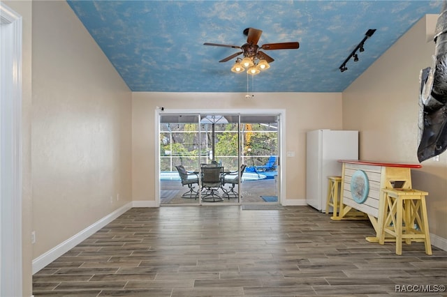 interior space with ceiling fan, rail lighting, and lofted ceiling