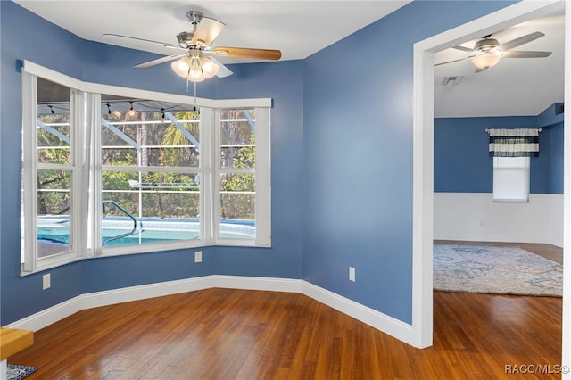 spare room featuring plenty of natural light, hardwood / wood-style flooring, and ceiling fan