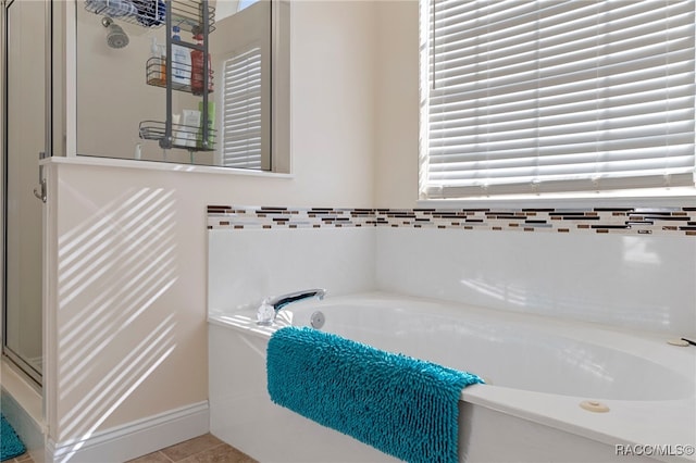 bathroom featuring a healthy amount of sunlight, tile patterned floors, and separate shower and tub