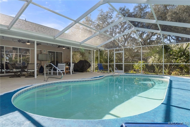 view of pool featuring a patio, ceiling fan, and glass enclosure