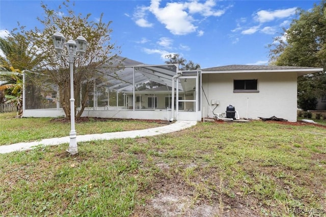 rear view of house featuring a lanai and a yard