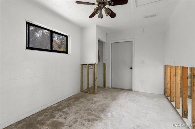 empty room featuring ceiling fan and a textured ceiling