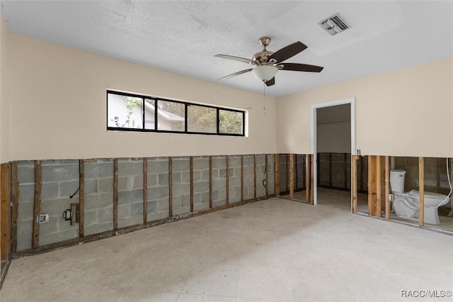 interior space with ceiling fan and a textured ceiling