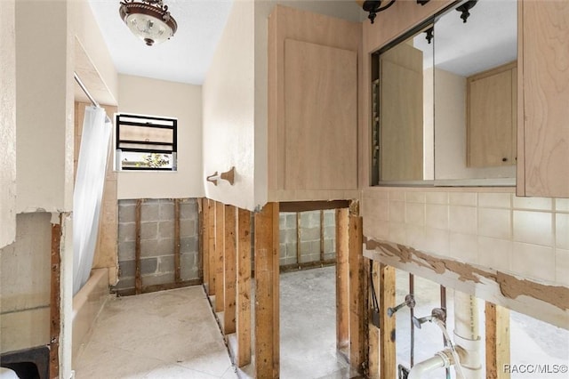 bathroom with shower / bath combo and tile walls