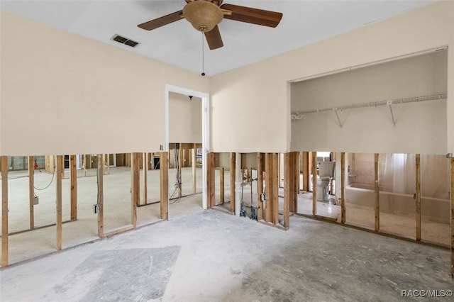 unfurnished bedroom featuring ceiling fan, concrete flooring, and two closets