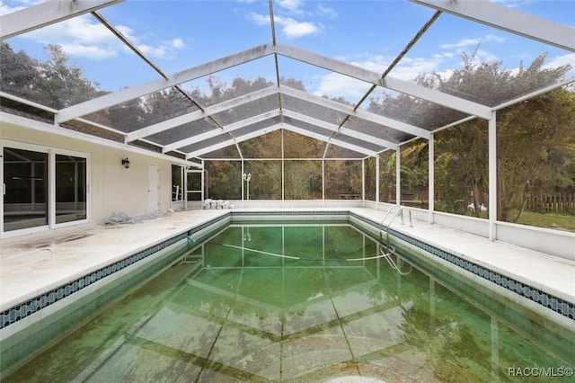 view of pool featuring glass enclosure and a patio