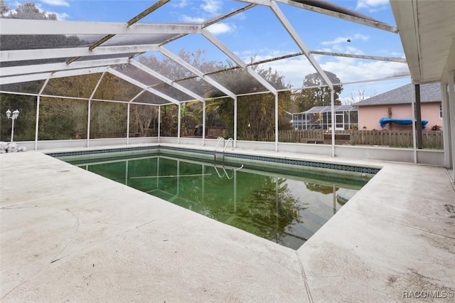 view of swimming pool with glass enclosure and a patio