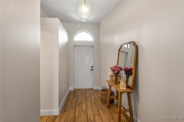 foyer featuring light wood finished floors and baseboards