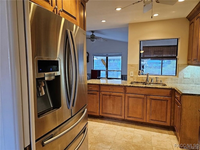 kitchen featuring a sink, stainless steel fridge, a ceiling fan, and brown cabinets