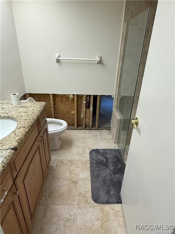 full bath featuring a tile shower, vanity, and toilet