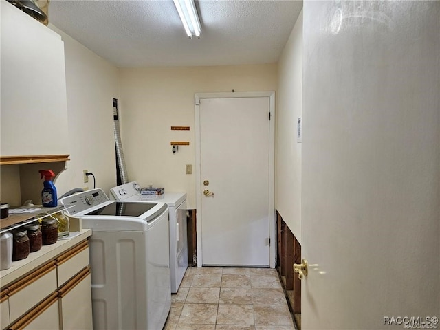 laundry room featuring cabinet space, washer and clothes dryer, and a textured ceiling