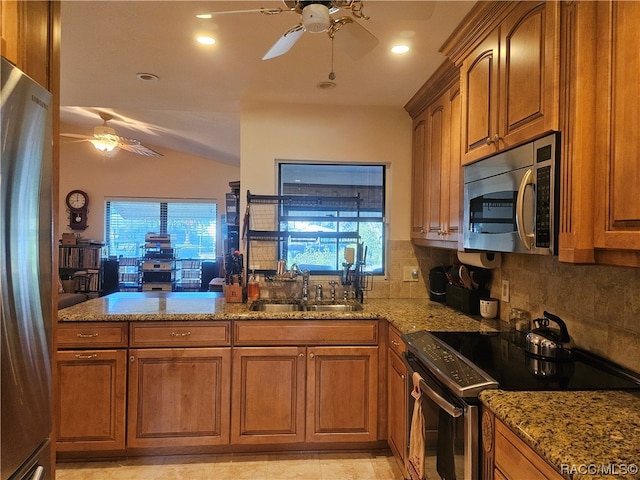 kitchen featuring backsplash, light stone counters, sink, and stainless steel appliances