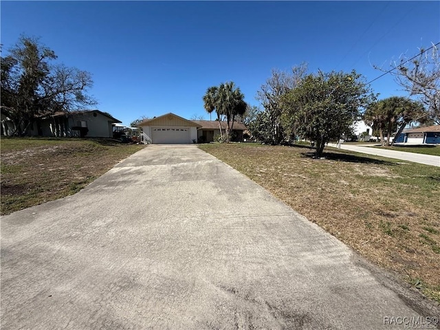 single story home featuring a garage, driveway, and a front lawn