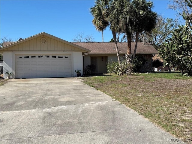 view of front of property with an attached garage, a front lawn, and concrete driveway