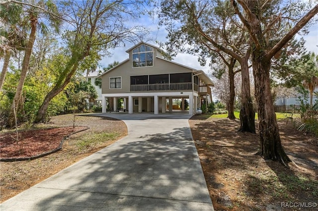 view of front of property with a carport, a sunroom, and driveway