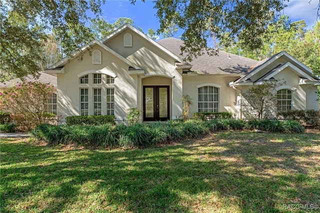 view of front of home featuring a front lawn and french doors