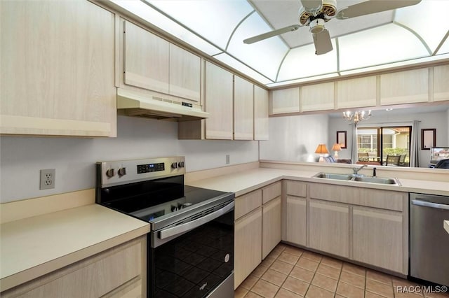 kitchen with under cabinet range hood, light brown cabinets, appliances with stainless steel finishes, and a sink