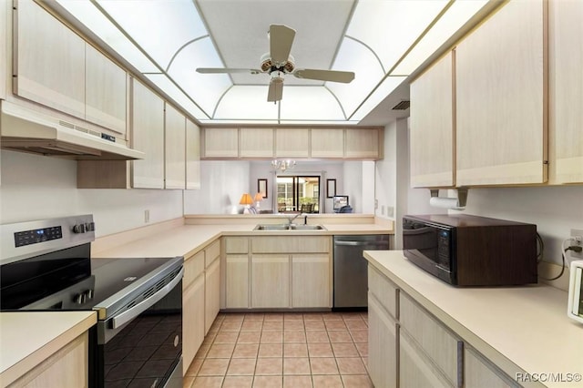 kitchen with a raised ceiling, stainless steel appliances, light brown cabinetry, under cabinet range hood, and a sink