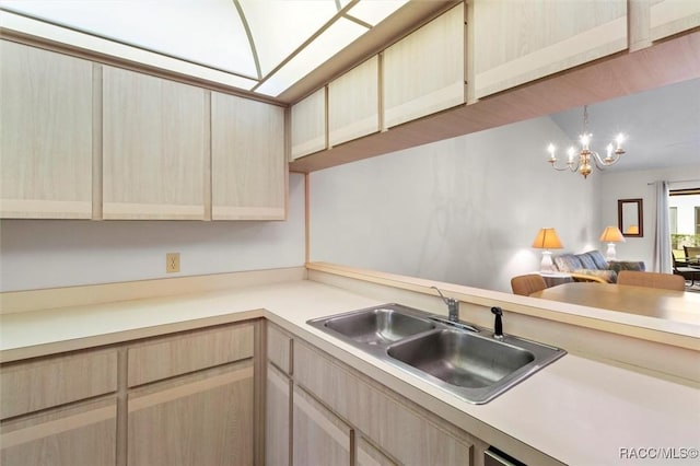 kitchen featuring light countertops, open floor plan, a sink, and light brown cabinetry