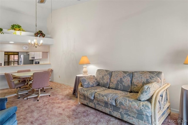 carpeted living area with a chandelier, high vaulted ceiling, and baseboards