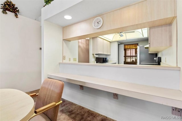 kitchen featuring light countertops, carpet, freestanding refrigerator, and baseboards