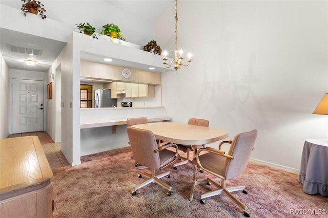 dining room with a notable chandelier, baseboards, visible vents, and light colored carpet