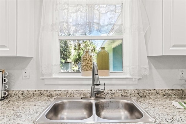 details featuring white cabinetry and sink