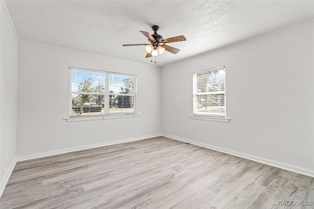 empty room with ceiling fan, light hardwood / wood-style flooring, and a textured ceiling