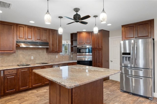 kitchen with stainless steel fridge, decorative light fixtures, and a kitchen island