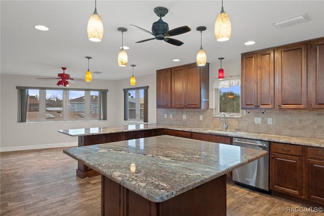 kitchen with pendant lighting, sink, dishwasher, and a kitchen island