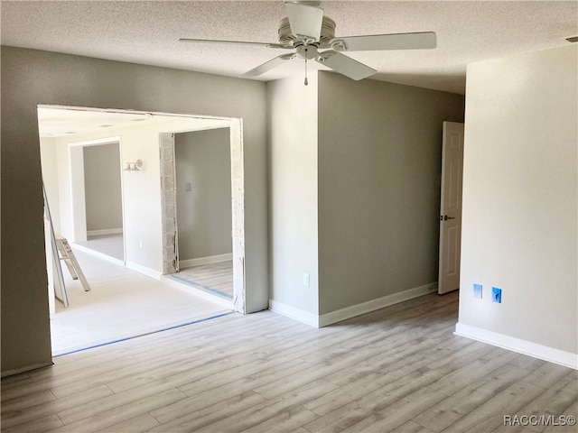 spare room with ceiling fan, a textured ceiling, and light hardwood / wood-style flooring