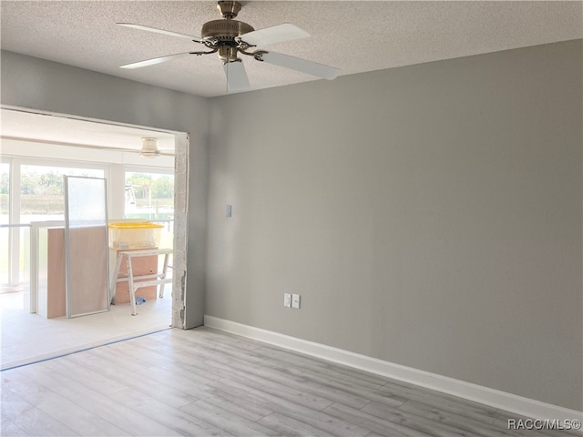 empty room with a textured ceiling, light hardwood / wood-style flooring, and ceiling fan