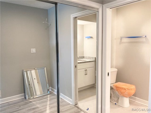 bathroom with vanity, wood-type flooring, and toilet