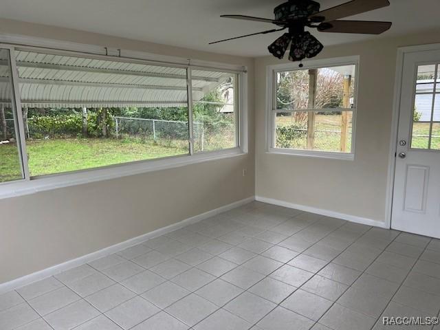 unfurnished sunroom featuring ceiling fan