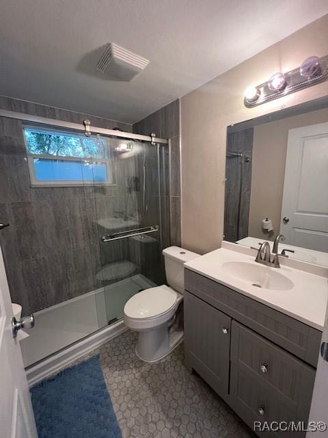 bathroom with a shower with door, vanity, and toilet