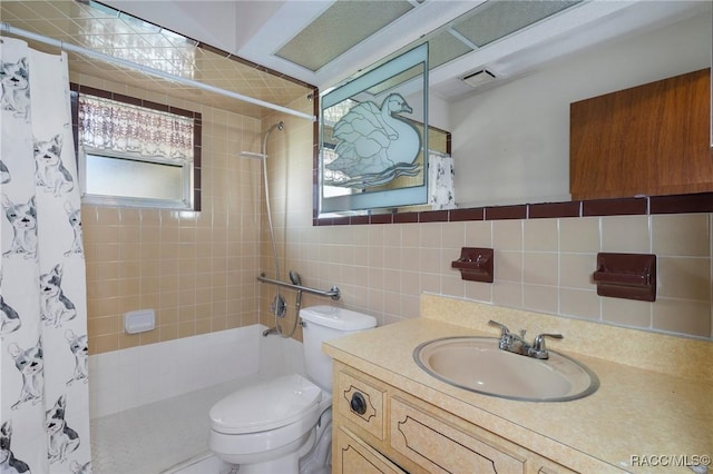 full bathroom featuring toilet, tile walls, vanity, and shower / bath combination with curtain