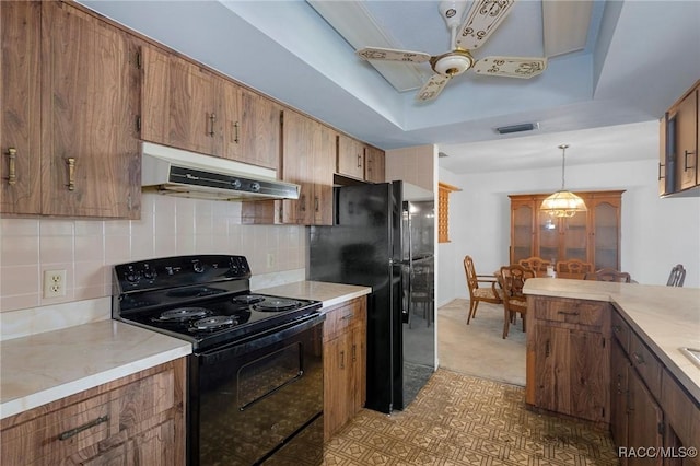 kitchen featuring black appliances, ceiling fan, decorative light fixtures, decorative backsplash, and a raised ceiling