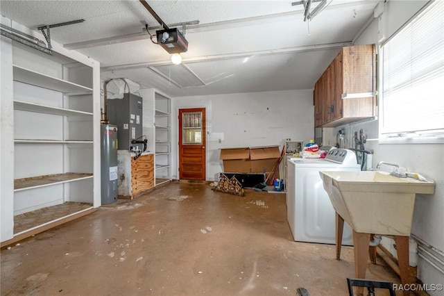 garage featuring heating unit, water heater, sink, a garage door opener, and washer and clothes dryer