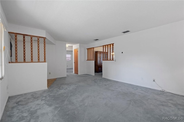 unfurnished living room featuring carpet flooring and a textured ceiling