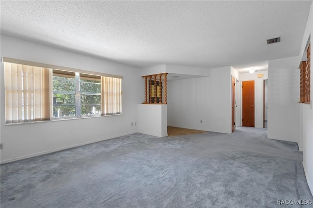 carpeted empty room with a textured ceiling