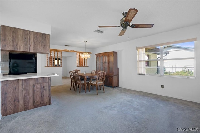 carpeted dining space with ceiling fan