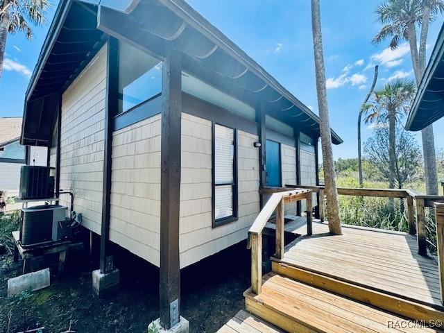 view of side of property with central AC and a deck