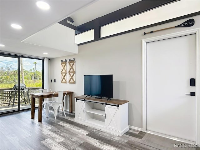 dining space with recessed lighting, baseboards, a wall of windows, and light wood finished floors