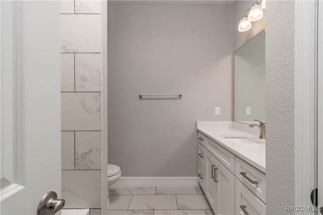 bathroom featuring marble finish floor, vanity, toilet, and baseboards