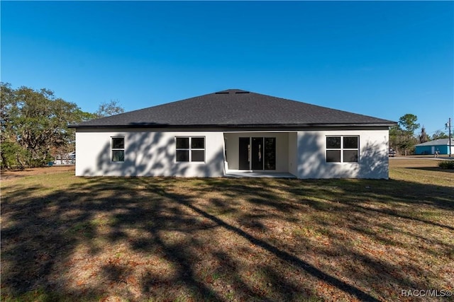 rear view of property featuring a yard