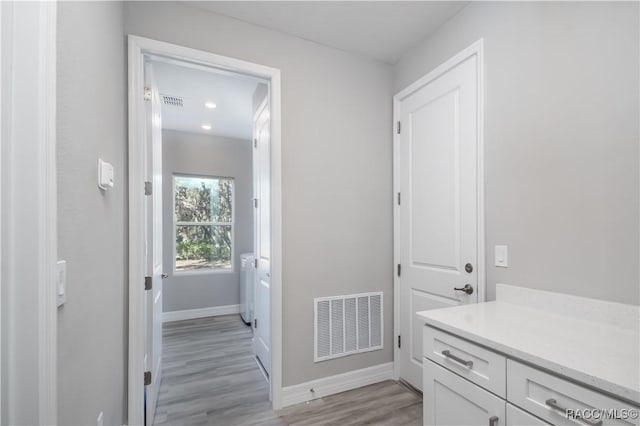 bathroom with vanity, wood finished floors, visible vents, and baseboards