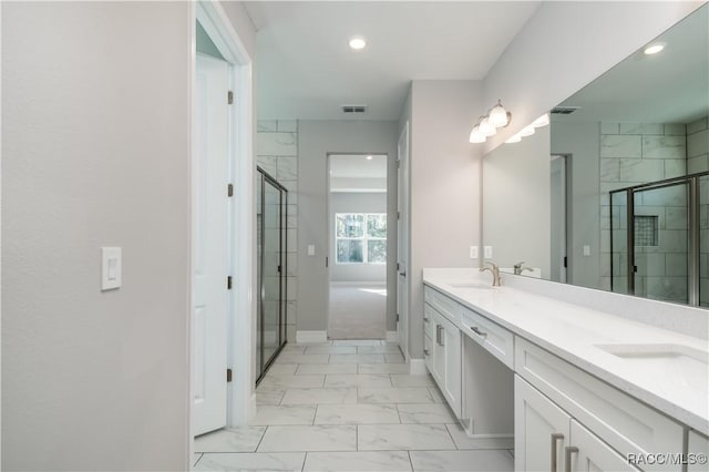 full bathroom featuring a stall shower, marble finish floor, a sink, and double vanity