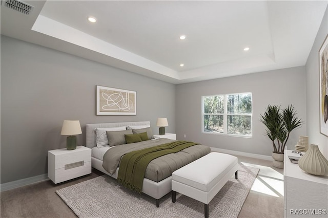 bedroom featuring baseboards, visible vents, a raised ceiling, and recessed lighting